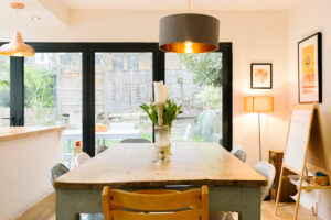 A photo of a dining table with a children's whiteboard int he corner 