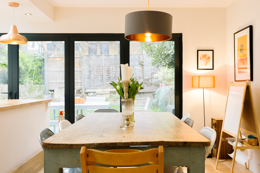 A photo of a dining table with a children's whiteboard int he corner