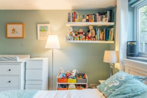 An image of a bedroom with a baby changing table and stuffed toys and books on the shelves